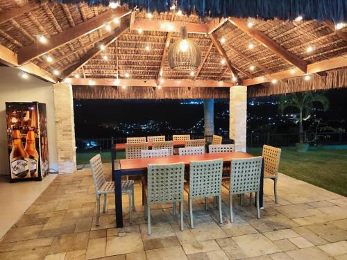 eine Terrasse mit einem Tisch, Stühlen und Lampen in der Unterkunft Flat bananeiras in Bananeiras