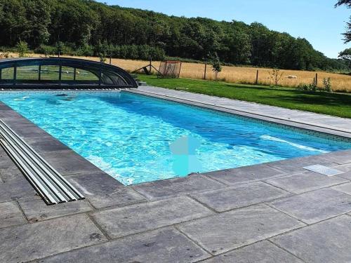 a swimming pool with blue water in a yard at Mölle Vattenmöllan in Mölle
