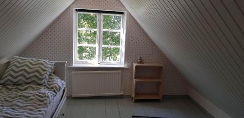 a attic room with a bed and a window at Mölle Vattenmöllan in Mölle