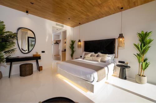 a bedroom with a large bed and a mirror at Ftelia Black Villas in Elia
