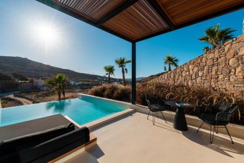 a villa with a swimming pool and palm trees at Ftelia Black Villas in Elia