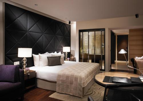 una camera con un grande letto con testiera nera di HOTEL Tu CASA DELHI AIRPORT a Nuova Delhi