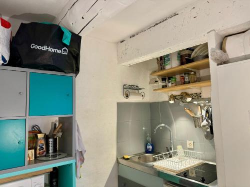 Elle comprend une petite cuisine avec des placards bleus et un évier. dans l'établissement Studio cosy hypercentre Aix, à Aix-en-Provence