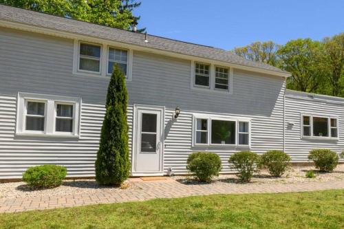 a white house with bushes in front of it at Trail-side Haven Retreat! Pet friendly in North Haven