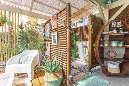 a garden room with a wooden pergola at Magnifique Bungalow et Jacuzzi au cœur des plages in Le Moule