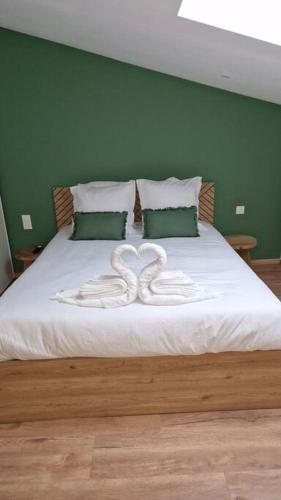 - un lit avec deux cygnes blancs sculptés dans le lit dans l'établissement Spa des ducs loft 1, à Bar-le-Duc