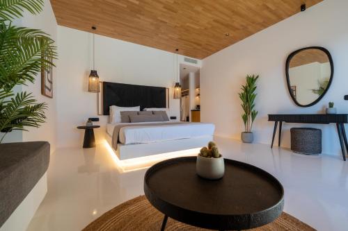 a bedroom with a bed and a table at Ftelia Black Villas in Elia