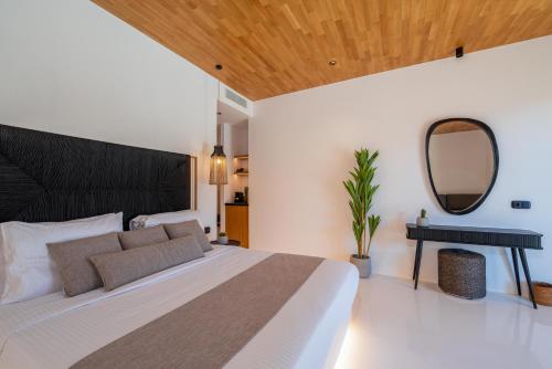a bedroom with a large bed and a mirror at Ftelia Black Villas in Elia