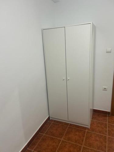 Armario blanco en una habitación con suelo de baldosa en Habitación D&D, en Valencia