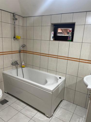 a bath tub in a bathroom with a sink at Vila Bjelopoljak - Ponijeri in Kakanj