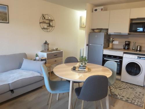 a kitchen and a living room with a table and chairs at Studio 24 m2 - 4 personnes in Besse-et-Saint-Anastaise
