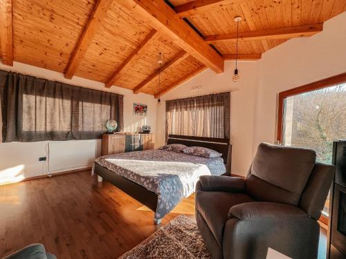 1 dormitorio con 1 cama y 1 silla en Olive garden family apartment with private pool, en Sežana