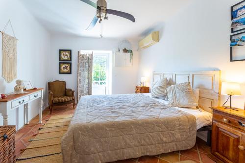 um quarto com uma cama e uma ventoinha de tecto em Charming country house em Santa Catarina da Fonte do Bispo