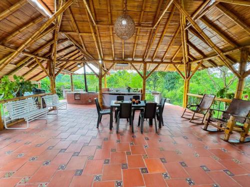 a patio with a table and chairs in a pavilion at Finca Villa Sophia! in Quimbaya