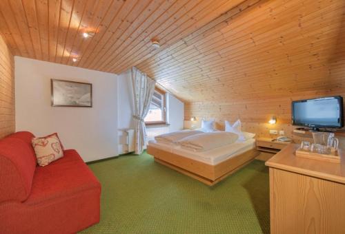 a bedroom with a bed and a tv and a couch at Haus Küng in Zürs am Arlberg