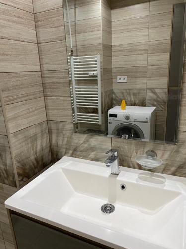 a bathroom with a white sink and a mirror at Vlastná izba 5min od letiska in Bratislava