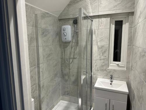 a bathroom with a shower and a sink at Ruxley Studios in Orpington