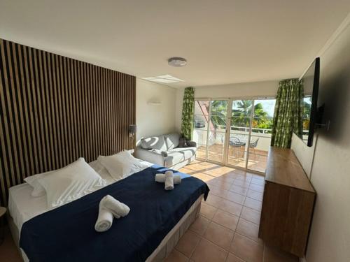 a bedroom with a bed with two towels on it at Studio Bruni Lodge in Sainte-Anne