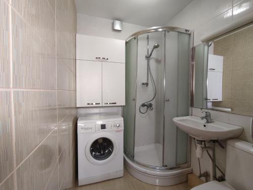 La salle de bains est pourvue d'un lave-linge et d'un lavabo. dans l'établissement 3M Bridge apartment SELF CHECK-IN, à Kaunas