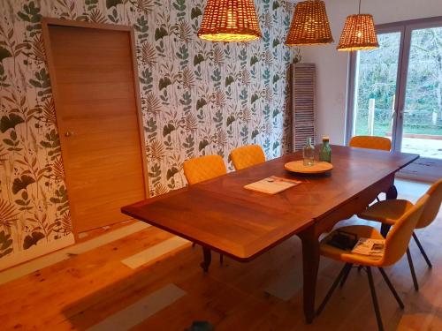 uma sala de jantar com uma mesa de madeira e cadeiras em Chambres d'Hôtes du Domaine de Bourbacoup em Tulle