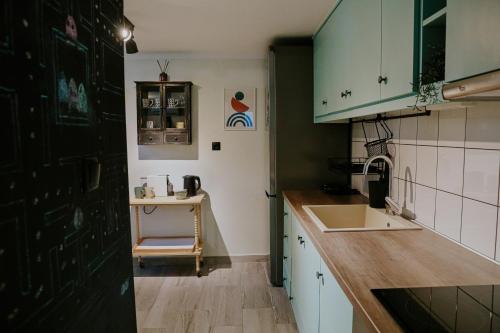 a kitchen with green cabinets and a sink at INOHO Moka Maisonette in Xanthi