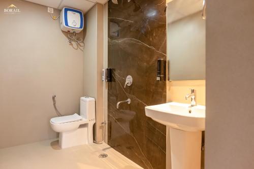 ein Bad mit einer Dusche, einem Waschbecken und einem WC in der Unterkunft Borail Homes in Silchar
