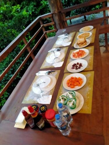 a table with plates of food and drinks on it at Ella nine arch spice garden in Ella