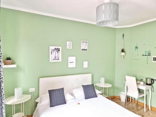 レヴァントにあるLe Giare B&Bの緑の壁のベッドルーム1室(白いベッド1台付)