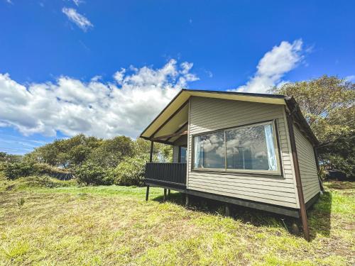 a tiny house sitting on top of a grass field at Maunga Roa Eco Lodge in Hanga Roa