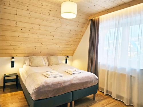 1 dormitorio con 1 cama con pared de madera en Willa Szyszka Zakopane en Zakopane
