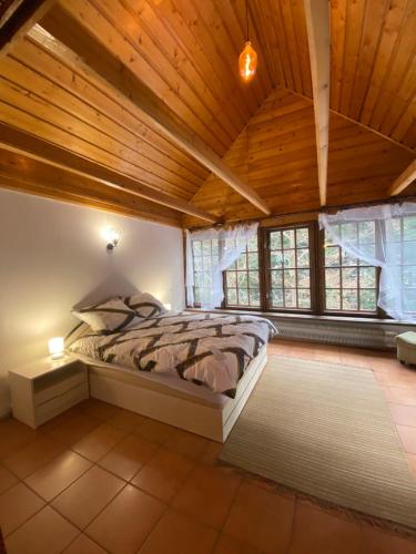 1 dormitorio con 1 cama en una habitación con techos de madera en Beskidzka Apartments, en Sucha Beskidzka