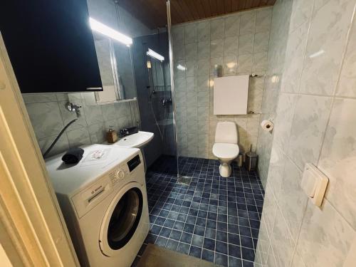a bathroom with a washing machine and a toilet at Hotel-standard design apartment with private sauna in Espoo