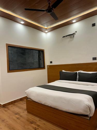 a bedroom with a large bed with a ceiling fan at Majestic Home manor in New Delhi