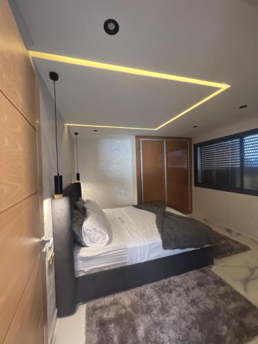 Chez Maria في القنيطرة: غرفة نوم مع سرير مع ضوء على السقف