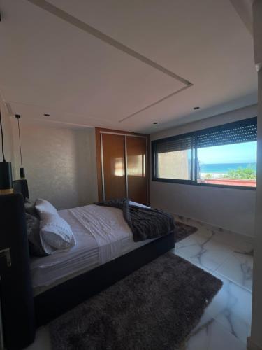 a bedroom with a bed and a large window at Chez Maria in Kenitra