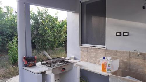 an outdoor kitchen with a stove and a window at Casa il capricorno in Syracuse