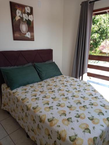 ein Bett mit einer Decke und einem Fenster in einem Schlafzimmer in der Unterkunft Recanto da Lagoa in Florianópolis