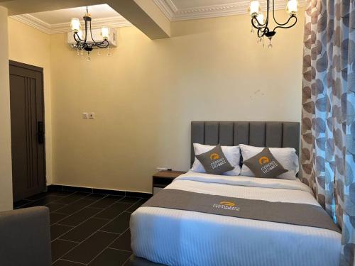 a bedroom with a bed with two pillows on it at Cereno Homes Accra in Accra