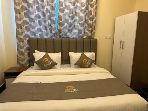a bedroom with a large bed with two pillows at Cereno Homes Accra in Accra