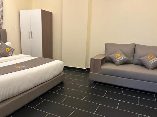 a hotel room with a bed and a couch at Cereno Homes Accra in Accra