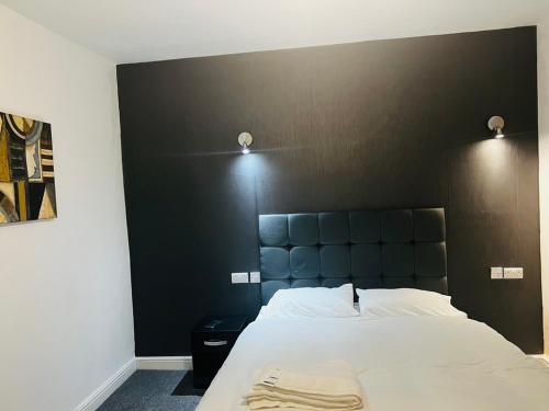 a bedroom with a large bed with a black headboard at The Pleasant House in Manchester