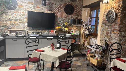 a kitchen with a table with chairs and a television at Luxury Corte Di Re Artù in Lucca