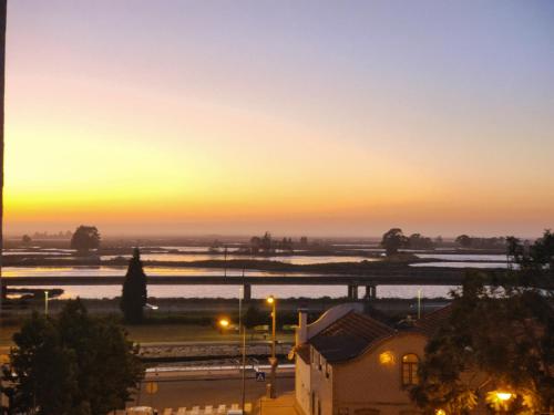 a sunset over a city with a river and a bridge at AveiroHouse in Aveiro