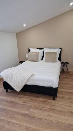 a bedroom with a large bed with white sheets and pillows at Spa des ducs loft 2 in Bar-le-Duc