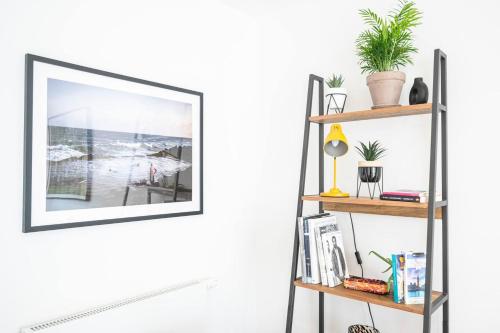 a shelf with a picture frame on a white wall at Pass the Keys Boutique Peckham Flat 12 mins to London Bridge in London