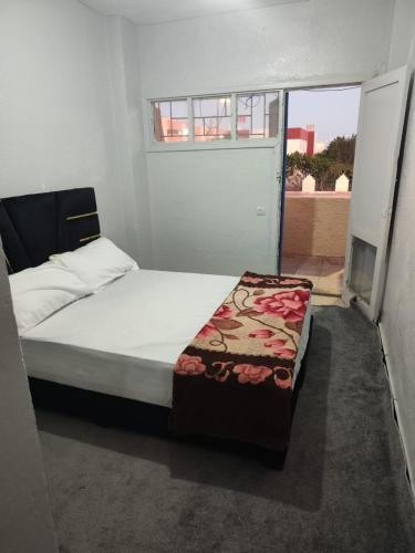 1 dormitorio con 1 cama en una habitación con ventana en Maison sahara, en Dakhla