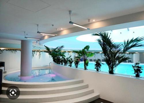 a building with a swimming pool with plants in it at Hanza Tower Sky SAUNA & JACUZZI & POOL in Szczecin