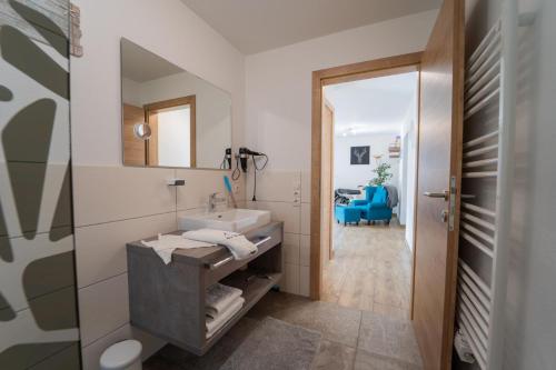 een badkamer met een wastafel en een spiegel bij Haus Faninger - SUMMERCARD included in Kaprun