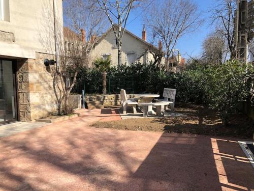 a picnic table and a bench in a yard at Chez Sophie et Gege. Maison de ville, deux chambres, de plain-pied in Figeac
