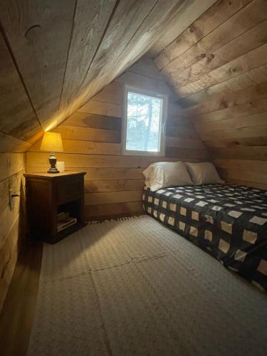 sypialnia z łóżkiem w drewnianym domku w obiekcie Tiny Home Bliss w mieście Harcourt